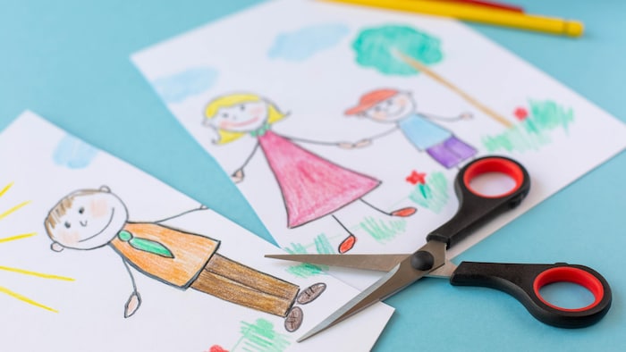 Un dessin représentant un papa, une maman et un garçon se tenant par la main. Le dessin est découpé en deux parties pour illustrer le contexte de séparation.