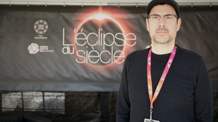 portrait devant l'affiche de l'éclipse du siècle