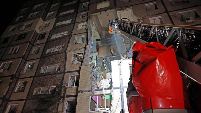 Des pompiers interviennent après une frappe russe qui a touché un immeuble résidentiel à Dnipro.