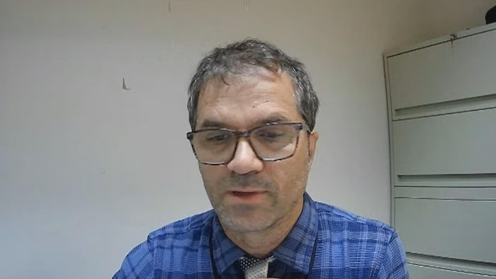 Un homme portant des lunettes assis