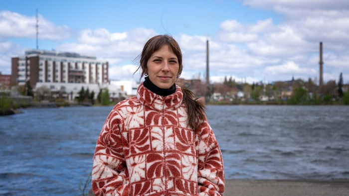 Marie-Ève Gauthier Arseneault devant le lac Osisko, l'hôpital de Rouyn-Noranda et les deux cheminées de la fonderie.