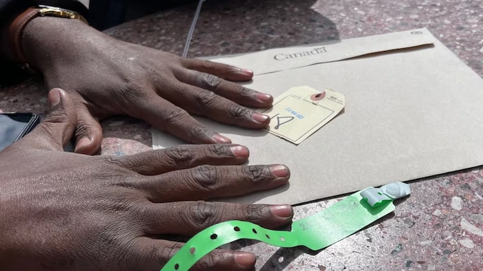 A man from Chad, who was detained at the Canada-U.S. border for three days, shows the number he was given while waiting to be released back into the United States. (Verity Stevenson/CBC)