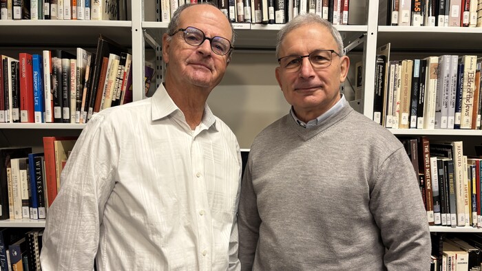 Deux hommes dans une bibliothèque.