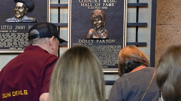 Des gens se rassemblent devant la plaque en l'honneur de Dolly Parton.