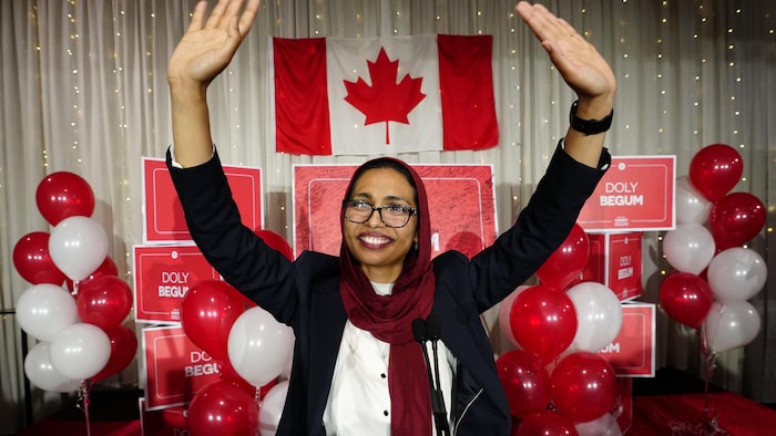 Doly Begum devant un drapeau canadien et des ballons après sa victoire lors de l'élection partielle de Scarborough-Sud-Ouest.