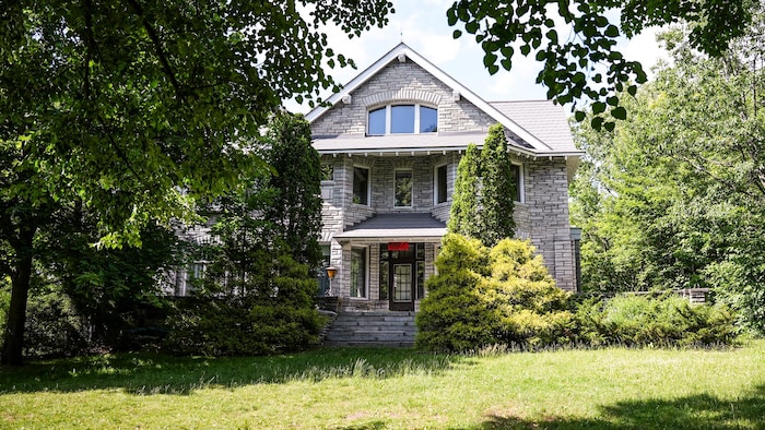 Une maison avec des arbres de chaque côté.