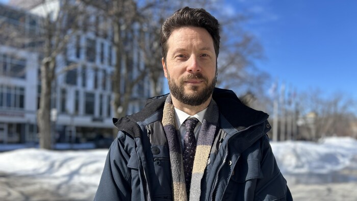 Un homme prend la pose devant la caméra en hiver.