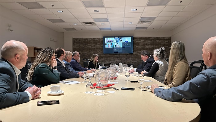 Des personnes attablées, en réunion