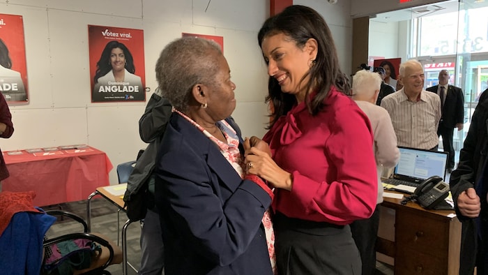 Dominique Anglade et une bénévole se prennent par les mains.