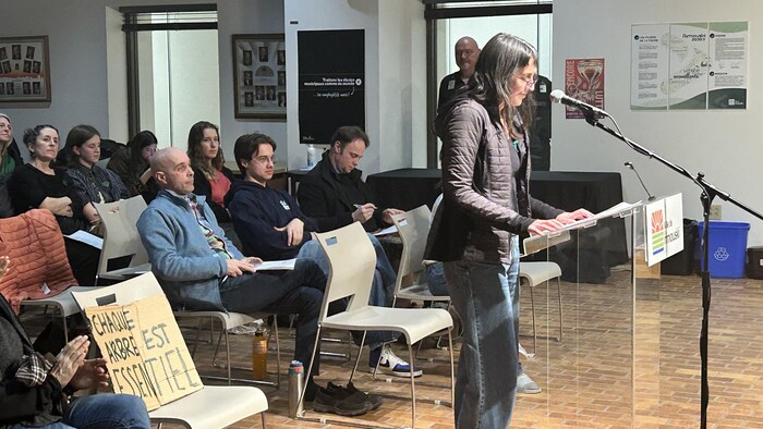 Dominique Bourassa devant un micro lors de la séance du conseil.