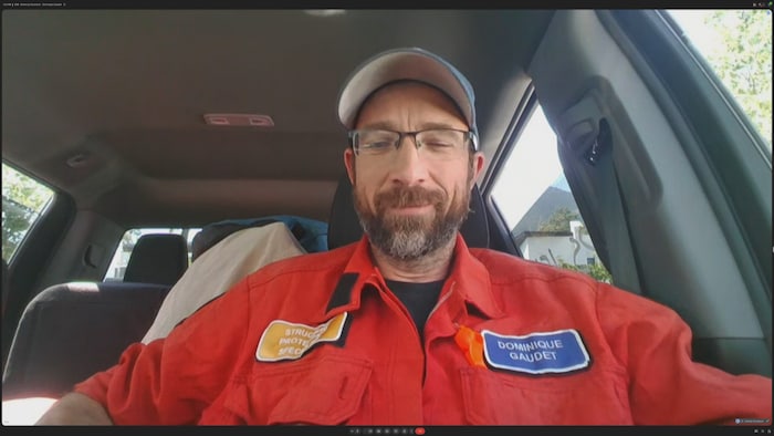 Le pompier Dominique Gaudet est assis dans sa voiture.