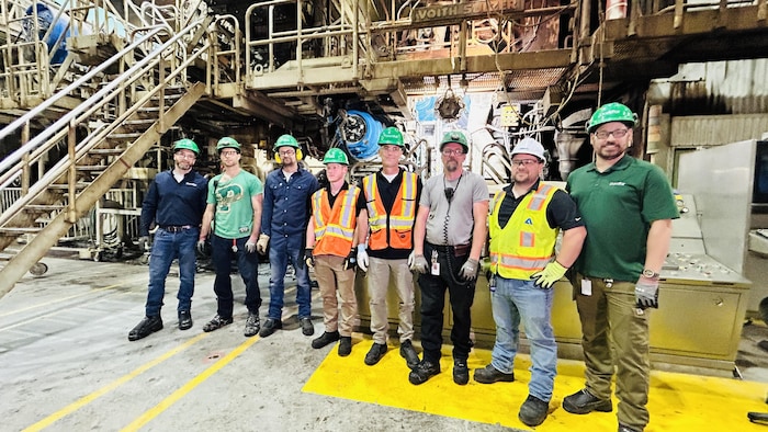 Une rangée de travailleurs dans une usine.