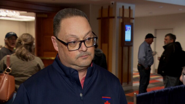 En entrevue, Donald Arseneault incline la tête et écoute attentivement une question.