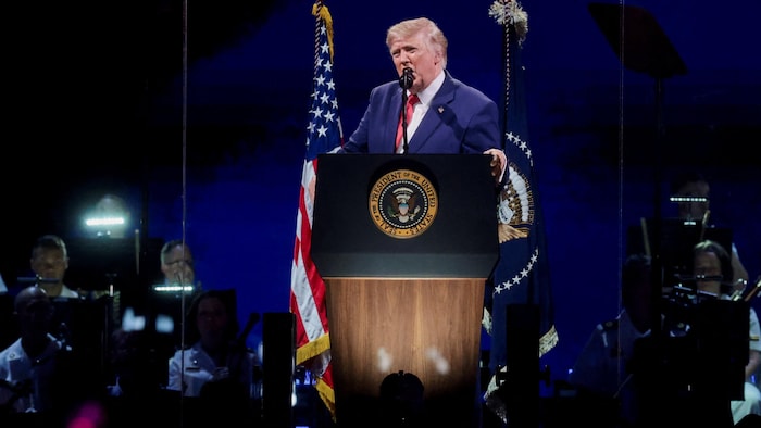 Donald Trump prend la parole devant un micro et un lutrin. 