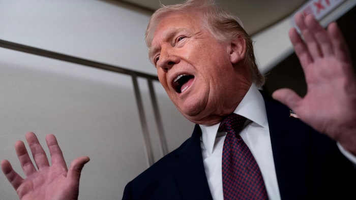 Le président américain Donald Trump s'adresse aux médias à bord d'Air Force One, alors qu'il se rendait de Floride à la base militaire Joint Base Andrews, dans le Maryland, le 11 janvier 2026. 