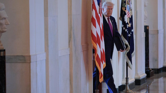 Donald Trump marche dans un corridor.