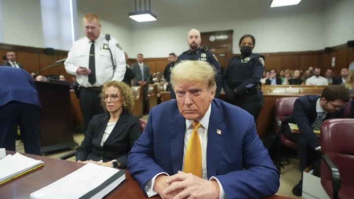 Donald Trump est assis en cour.