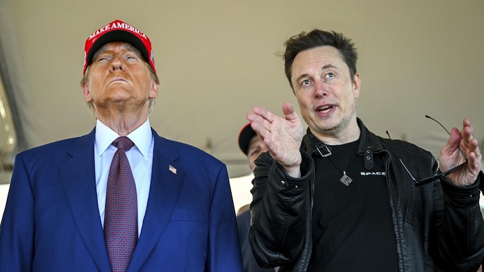 Donald Trump, coiffé d'une casquette rouge MAGA, regarde au loin alors qu'Elon Musk parle en gesticulant.
