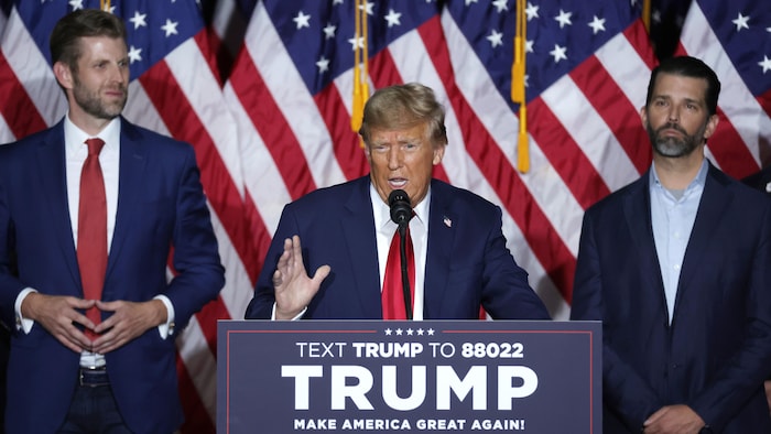 Donald Trump parle dans un micro, entouré de ses fils.