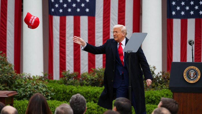 Le président Donald Trump lance une casquette MAGA devant une foule de partisans.