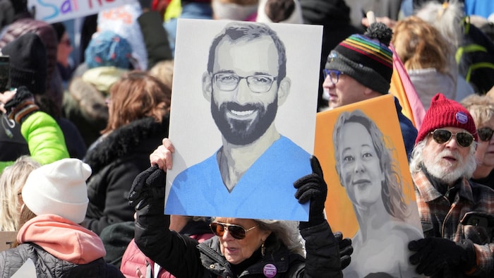 Des manifestants brandissent des pancartes représentant Renee Good et Alex Pretti.