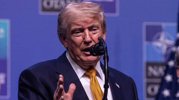 Donald Trump parle dans un micro en conférence de presse.