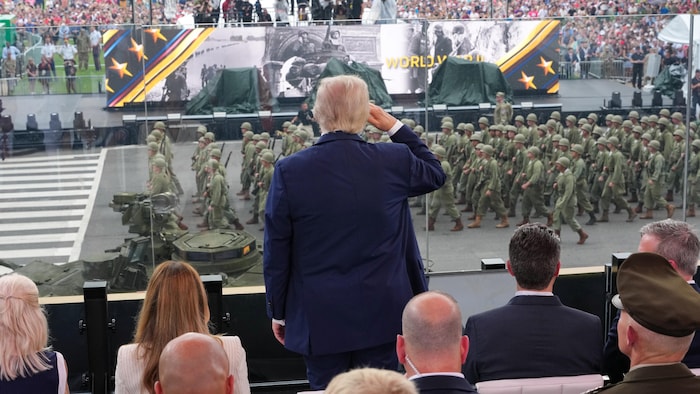 Donald Trump, de dos, fait un salut militaire à des troupes qui défilent devant lui, à Washington.