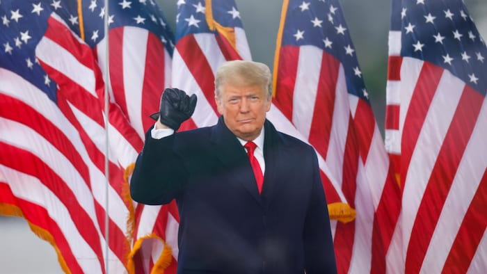 Donald Trump a le poing fermé ganté de noir levé en l'air. 