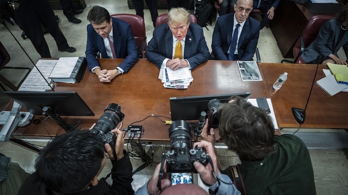 Photographers capture Donald Trump, sitting next to his lawyers Todd Blanche and Emile Bove.