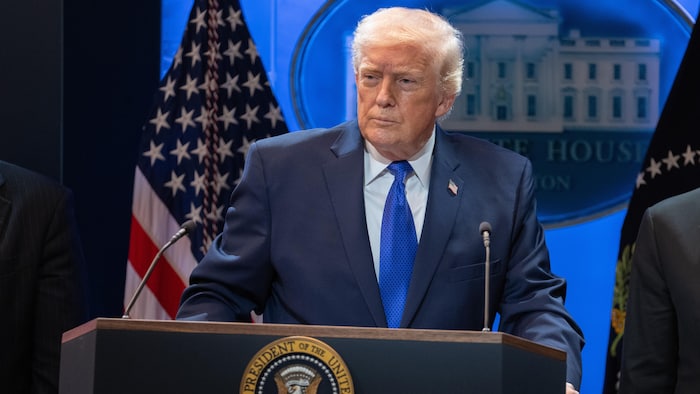 Donald Trump parle derrière un lutrin.  
