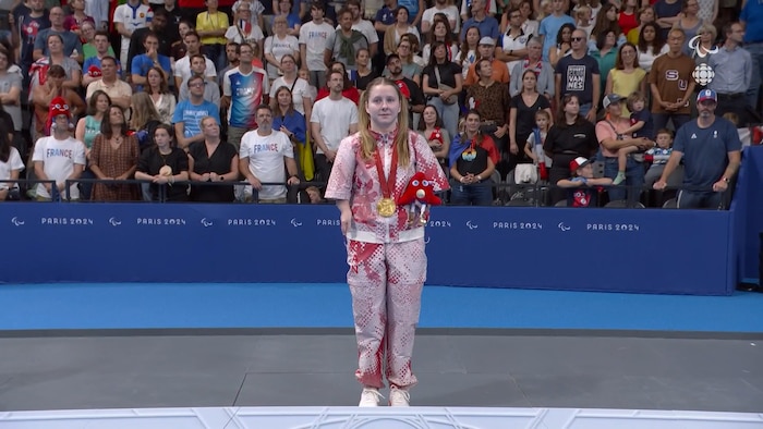Une femme se tient debout sur le podium.