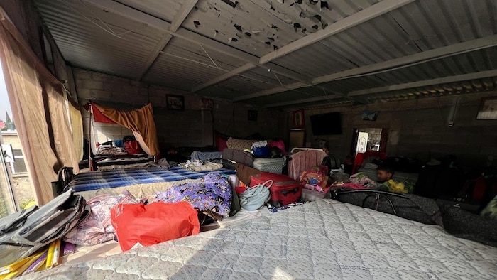 Une chambre avec plusieurs lits et des bagages épars.