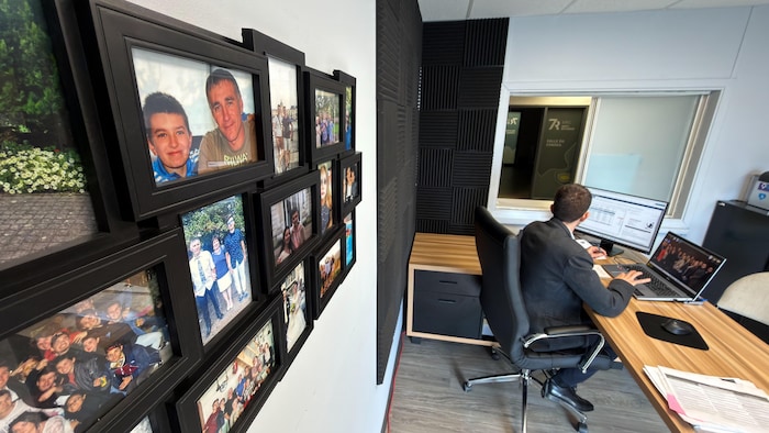 Benjamin Ducornait dans son bureau. Des images de sa famille sont positionnées sur un mur.