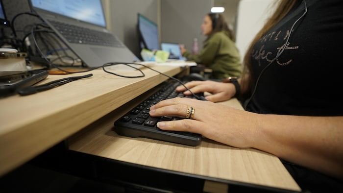Des mains sur un clavier d'ordinateur.