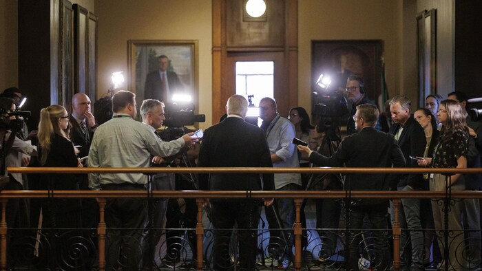 Le premier ministre Doug Ford, de dos, répond aux questions des journalistes.