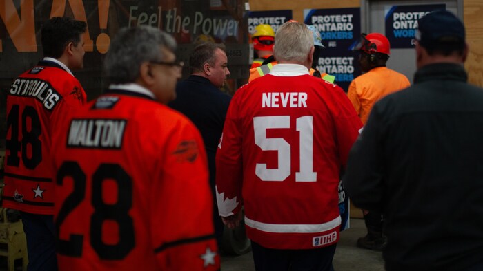 Doug Ford fait son entrée à une conférence de presse en portant un chandail de hockey où il est écrit « Never 51 ».