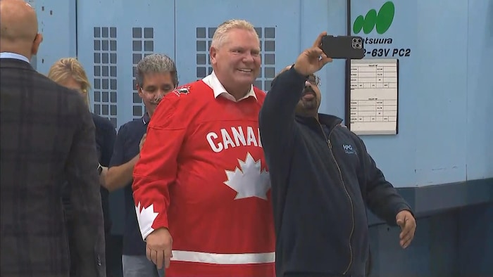 Doug Ford pose avec un travailleur dans une usine.
