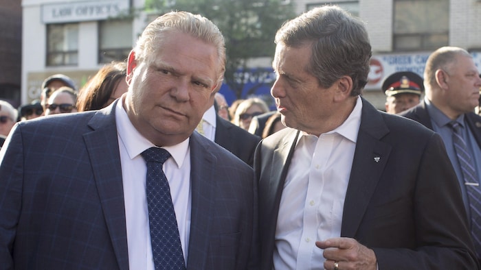 Le premier ministre ontarien Doug Ford et le maire John Tory lors d'un rassemblement en hommage aux victimes d'une fusillade à Toronto.