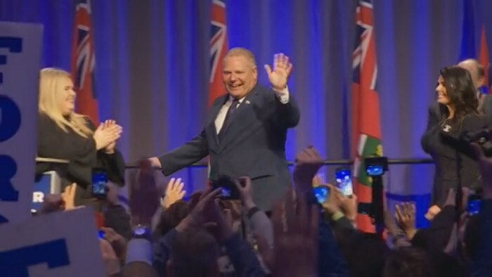 Doug Ford, sur une scène, salue la foule.