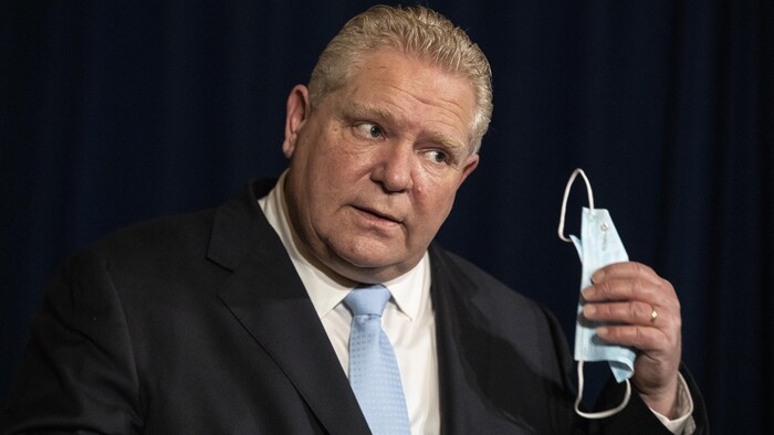 Doug Ford en point de presse enlève son masque.