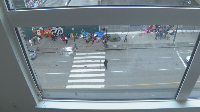 Fenêtre de l'appartement qui donne directement sur la rue où se trouvent des personnes vulnérables.
