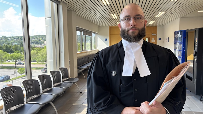 Un avocat pose dans un corridor du palais de justice.