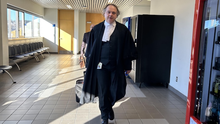 Un avocat marche dans un corridor du palais de justice de Chicoutimi.