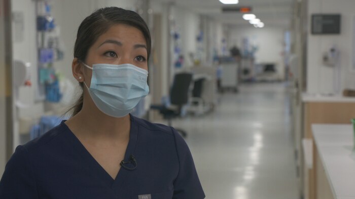 Une médecin portant un masque dans un corridor d'hôpital