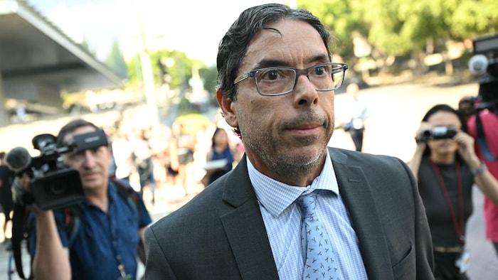 Le médecin est suivi par des journalistes à sa sortie du tribunal. 