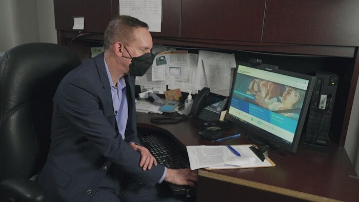 A man looks at a computer screen.