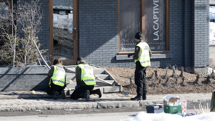 Des policiers recueillent des indices sur une scène de crime.
