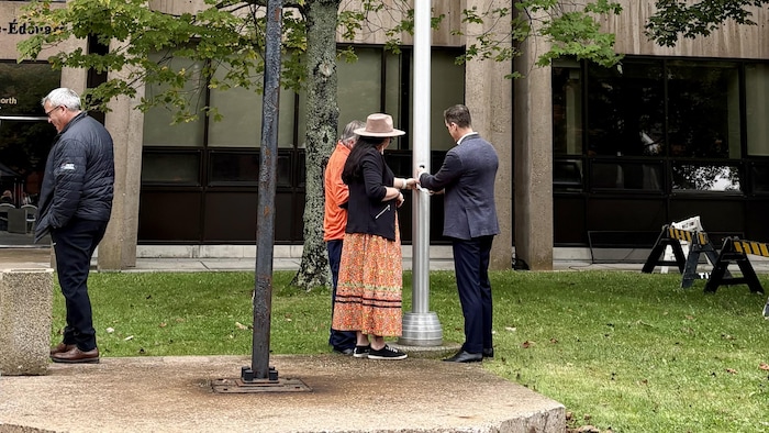 La cheffe Tabatha Bernard et le premier ministre Rob Lantz abaissent le drapeau de l'Île-du-Prince-Édouard.