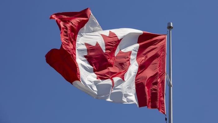 Un drapeau du Canada flottant dans les airs à Toronto près de l'intersection des artères Eglinton et Pharmacy, le 27 avril 2023.