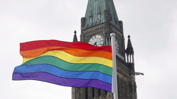 Un drapeau arc-en-ciel représentant le mouvement LGBT flotte devant la tour de la Paix du parlement, à Ottawa.